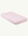 Sábana bajera con protector impermeable cuna 60x120 cm color rosa colocada sobre colchón.