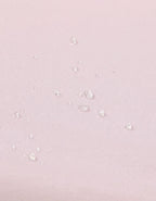 Detalle de la superficie impermeable de la sábana bajera con protector para cuna 70x140 cm color rosa.