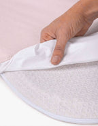 Detalle de la capa impermeable de la sábana bajera con protector para minicuna 50x90 cm color rosa.