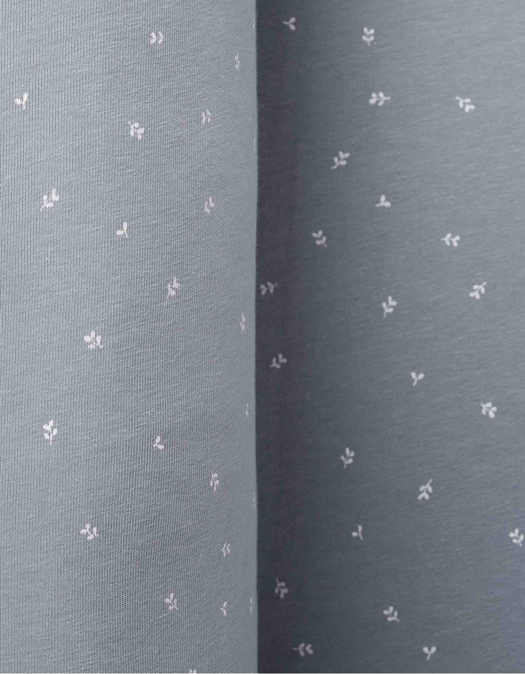 Detalle del cojín protector Hojas Blancas con estampado floral en algodón orgánico certificado