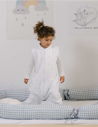 Cojín protector Vichy Gris colocado en la cama con un niño más mayor, en algodón orgánico.
