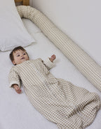 Cojín protector Vichy Sand en la cama con el bebé descansando, en algodón orgánico.