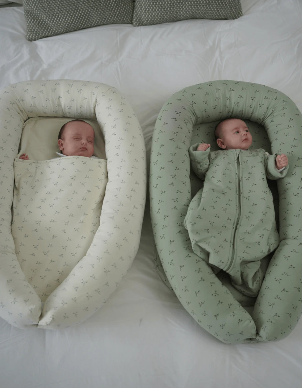 Dos bebés descansando en cunas nido Olive Cream, diseñadas para aportar confort, protección y bienestar.