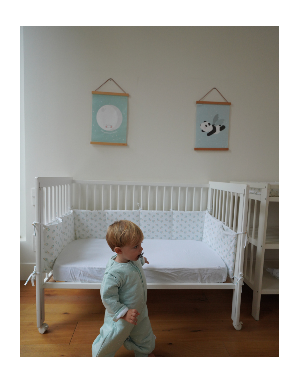 Protector de cuna Leaves de algodón orgánico con estampado de hojas, instalado en cuna infantil para proteger los laterales y crear un entorno seguro y confortable para el bebé.