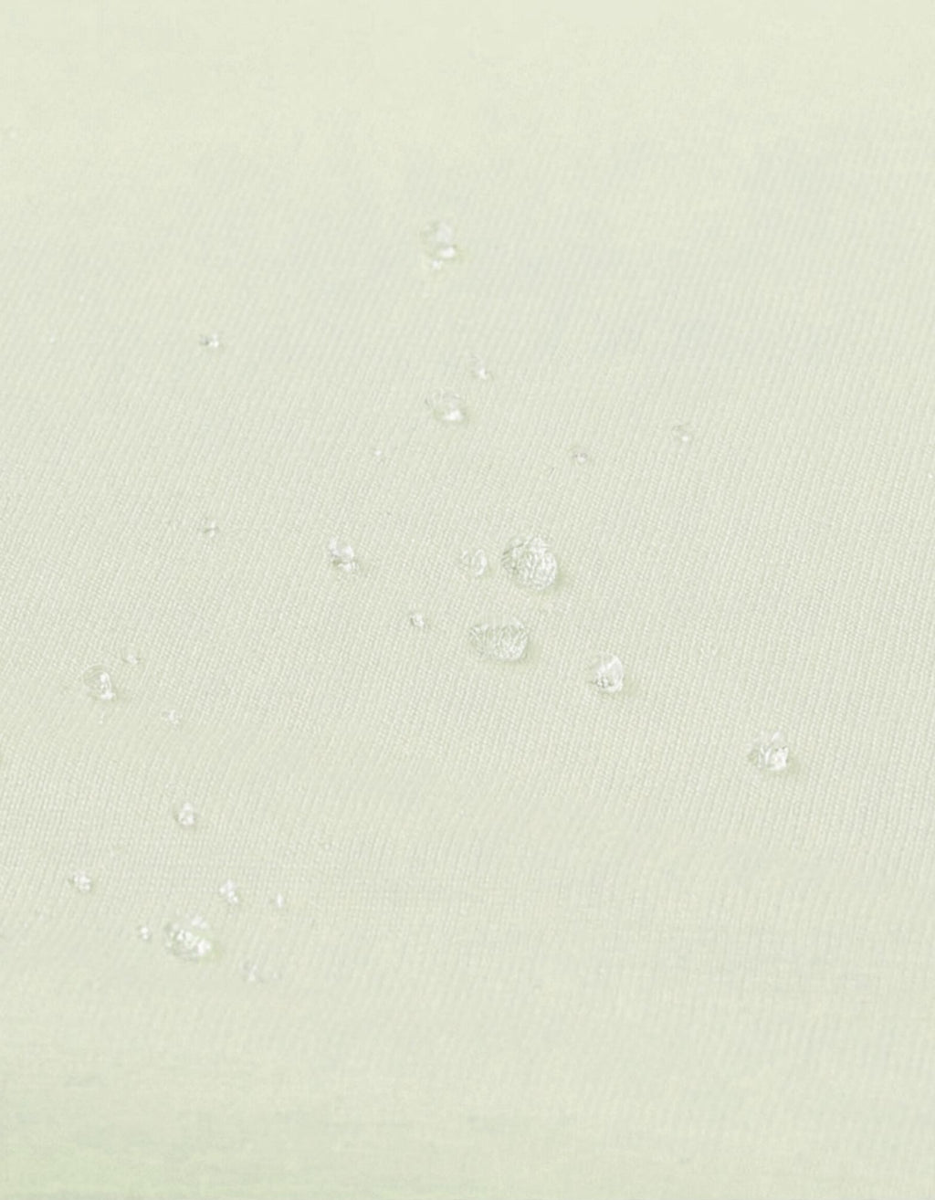 Detalle de la superficie impermeable de la sábana bajera con protector para cuna 70x140 cm color arena.