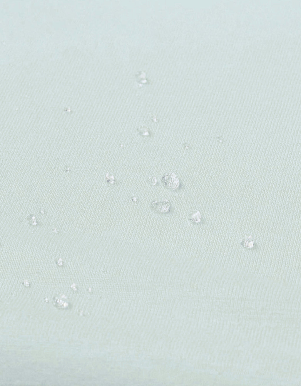 Detalle del tejido impermeable de la sábana bajera con protector para cuna 70x140 cm color agua