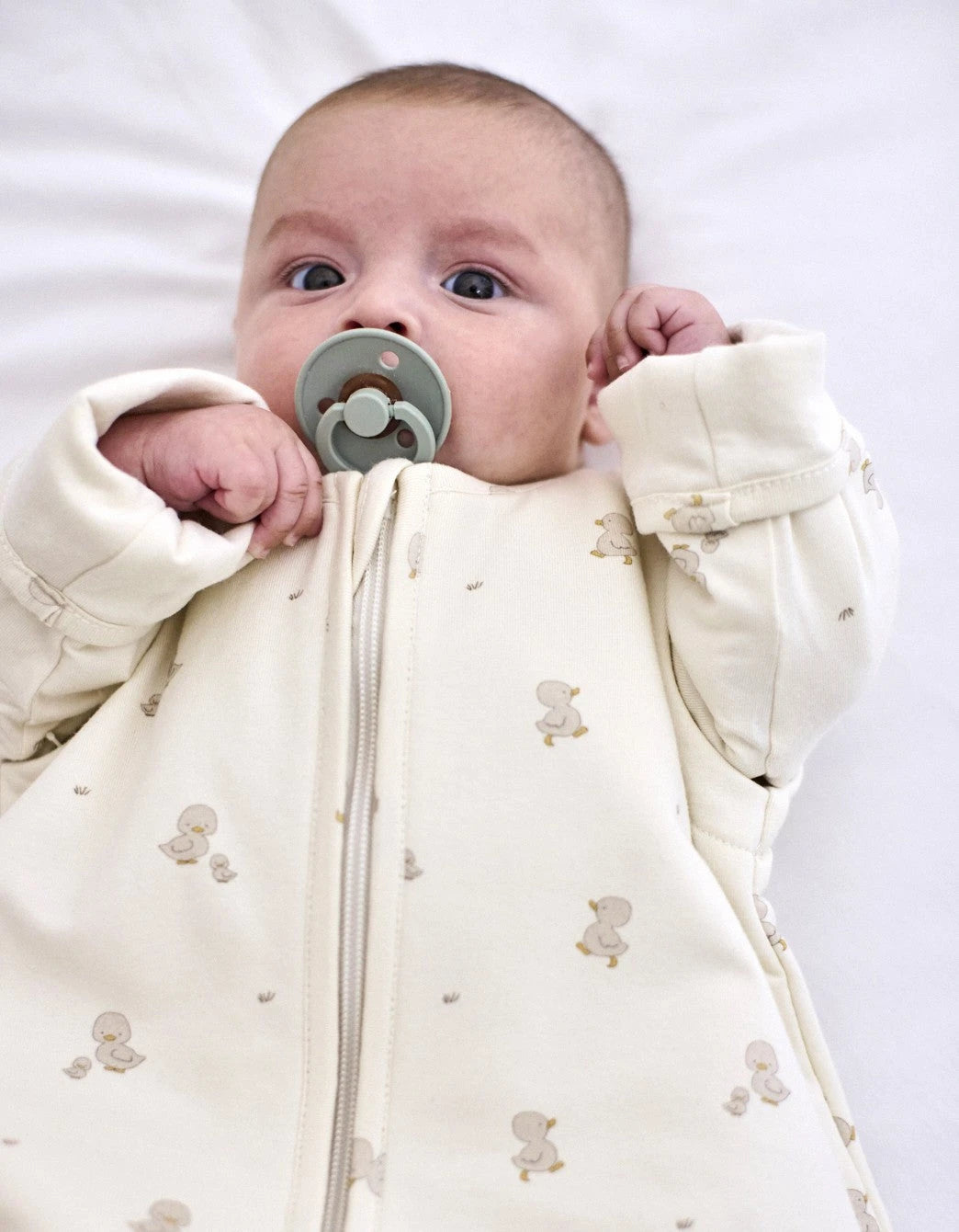 Bebé usando saco de dormir entretiempo Ducks TOG 1,5 con mangas desmontables.