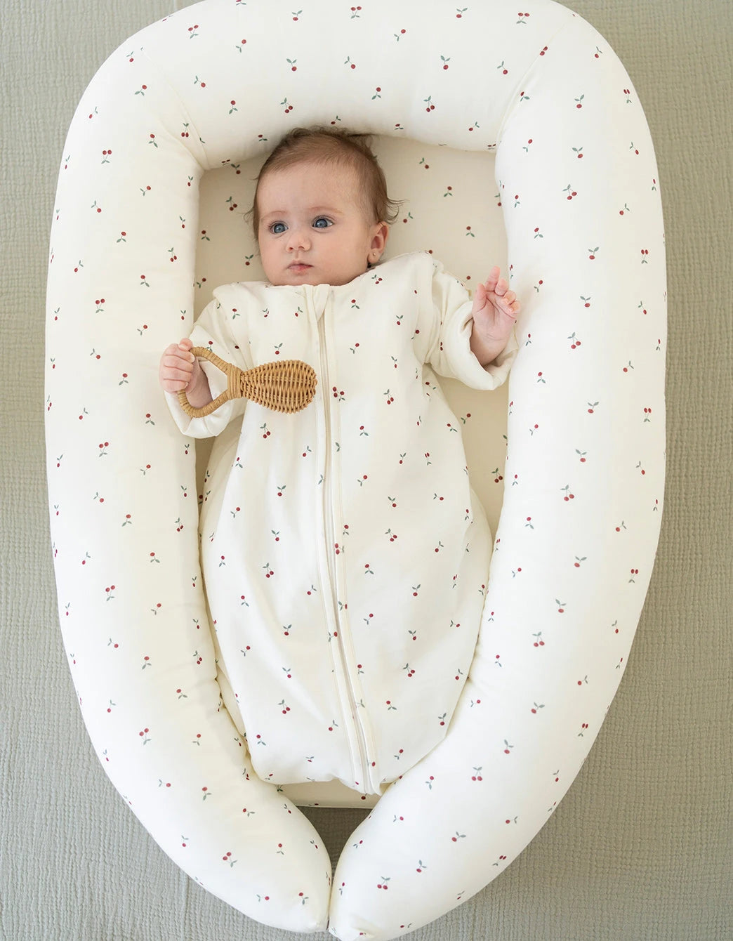 Saco de dormir bebé Cherries TOG 1,5 con estampado de cerezas en uso